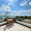 Sonnige Dach-Terrasse mit Blick ins Grüne und auf den See.