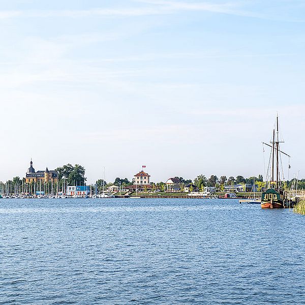 Kleiner Hafen, im Hintergrund auf einem Hügel sitzt ein gelbes Schloss.