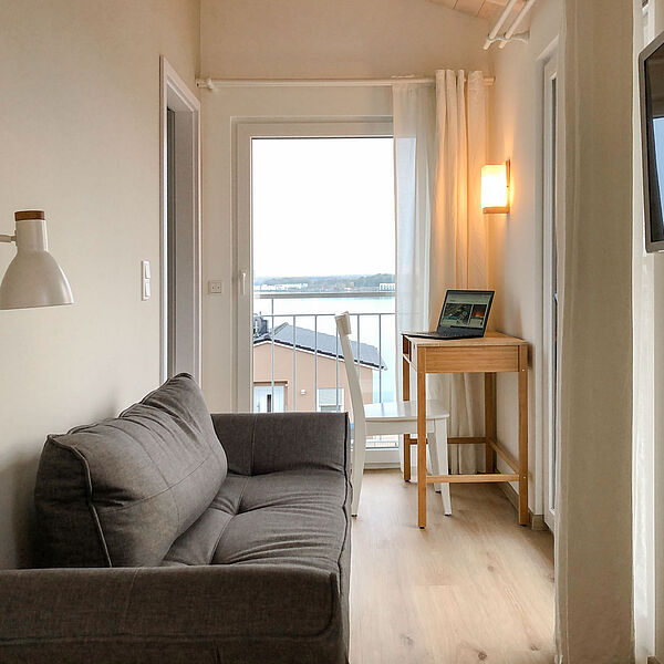 Wohnung 4: Gemütliche Couch im Wohnbereich mit Blick auf den Hainer See.
