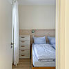 Wohnung 2: Gemütliches Schlafzimmer mit Bett und Kommode.