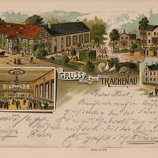 Gemalte Postkarte mit der Überschrift "Gruss aus Trachenau". Darunter ein handschriftlicher Text an den lieben Kurt. Im oberen Teil der Karte sind vier Bilder von einem Saal, dem Friedrischs-Stift und der Schule sowie einem großen unbenannten Gebäude.