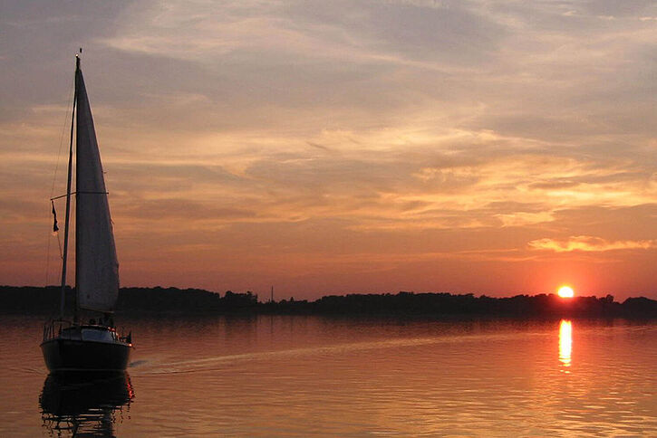 Mit dem Boot auf dem Cospudener See im Sonnernuntergang.