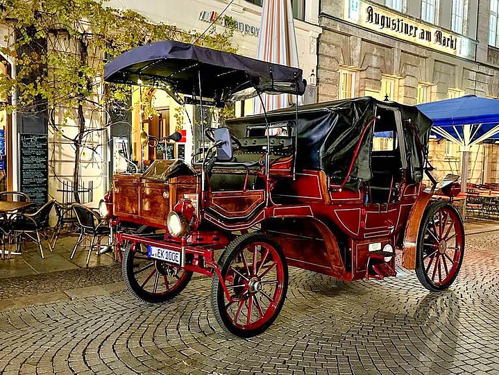 Rote E-Kutsche mit schwarzem Verdeck für Fahrer und Passagiere
