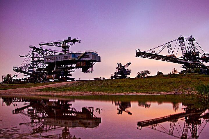 Braunkohle-Bagger im Abendrot spiegeln sich im See