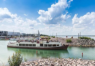 Personenschiff auf türkisem Zwenkauer See, Ausfahrt aus dem Hafen