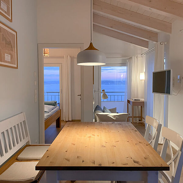 Blick zur Blauen Stunde vom Esstisch im Wohnzimmer. Links geht eine Tür zum Schlafzimmer.