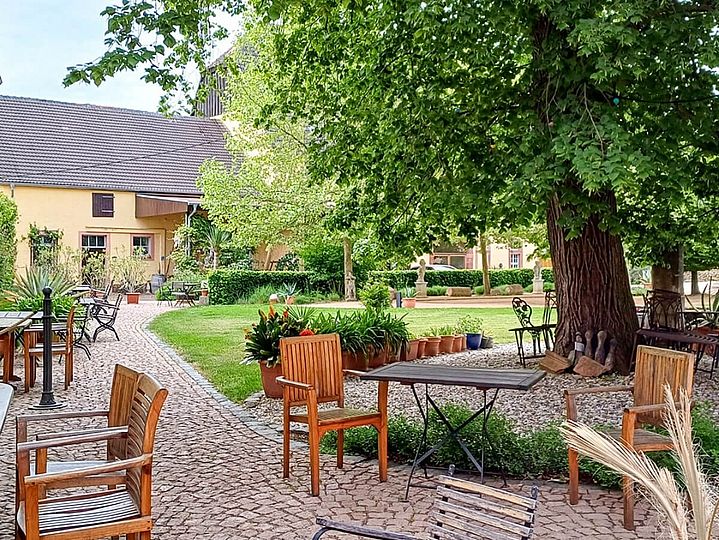 Innenhof mit Garten, Tischen und Baum