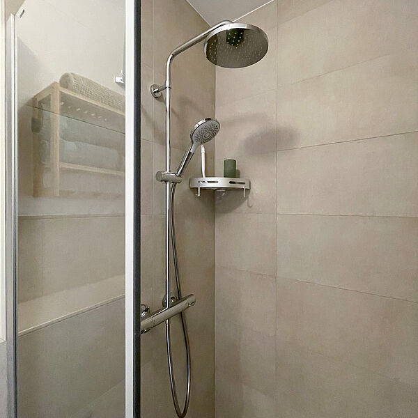 Dusche mit zwei Duschköpfen und Glaswand.
