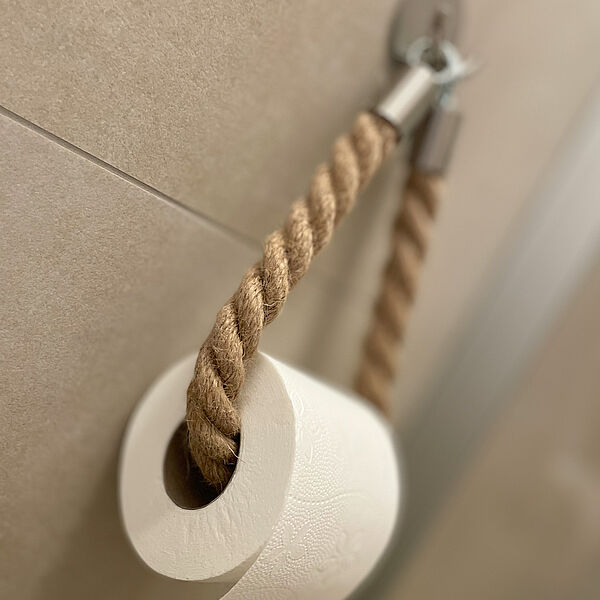 Eine Rolle Toiletten-Papier an einem Tau aufgehängt.