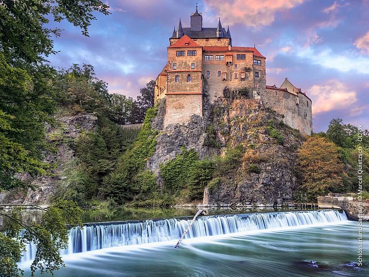 Burg Kriebstein im Sonnenuntergang vor einem Fluss