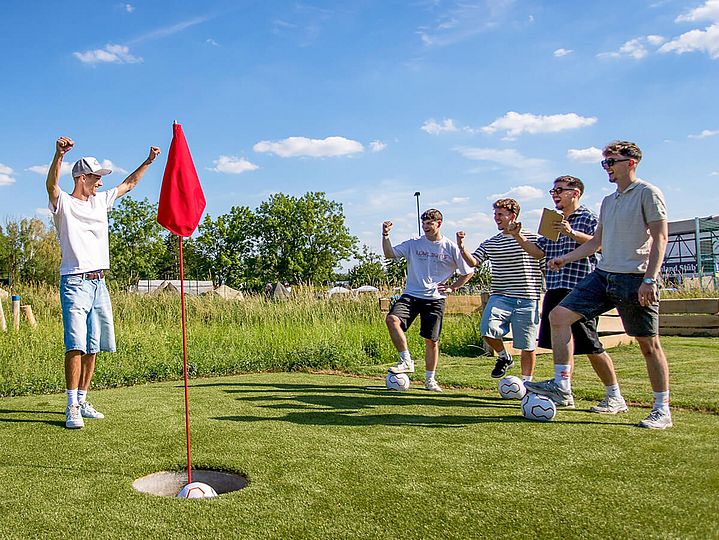 Gruppe junger Männer freut sich über Ball im Ziel
