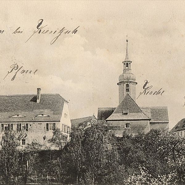 Vergilbte-braun-weiße Ansichtskarte von Hain mit Dächern von Kirchturm, Pfarrhaus und Schule