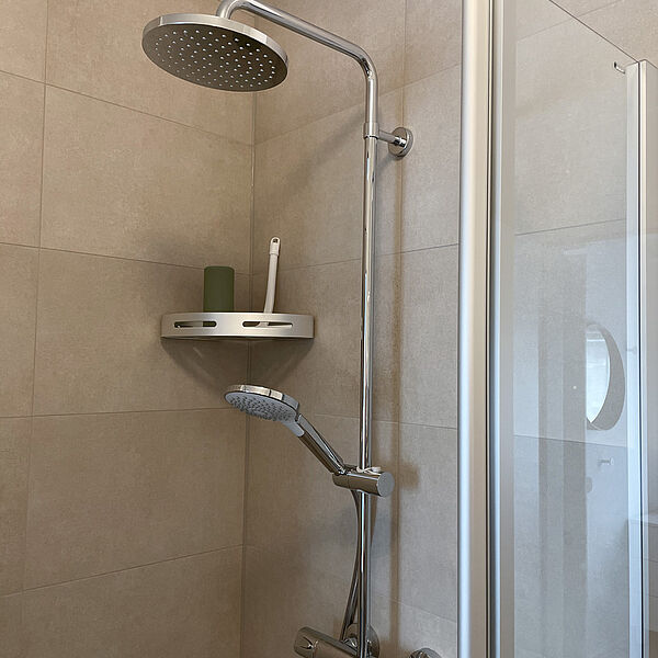 Glas-Dusche mit festem und beweglichem Dusch-Kopf.