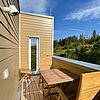 Sonniger Balkon mit Holz-Möbeln.