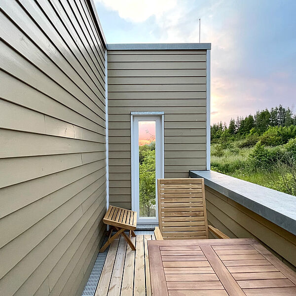 Balkon vom Schlaf-Zimmer 2 mit Holz-Möbeln.