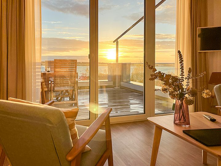 Abendsonne scheint durch die Terrassen-Fenster ins Wohnzimmer