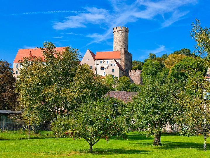 Burg Gnandstein im Sommer vor Obstwiese